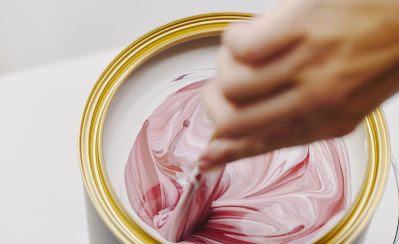 Picture of pink and red pigments being mixed into paint